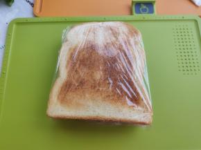 另一片吐司上也涂抹少许色拉酱，然后盖在之前的吐司上，用保鲜膜把吐司包裹起来，一定要包紧，不然容易散开的哟。