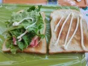 接着铺上鸡蛋片，喜欢色拉酱再挤上一点，喜欢番茄酱也可以加点，再铺上香肠片、生菜。