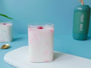 新鲜的美国蔓越莓用勺子挤出汁水与酸奶、香瓜粒拌一起喝。