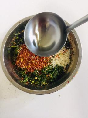 捣好的香椿倒出来，放入两勺不辣的粗辣椒面，一勺巨辣的细辣椒面，适量的白芝麻，第一次淋上热油，搅拌均匀！