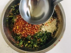 捣好的香椿倒出来，放入两勺不辣的粗辣椒面，一勺巨辣的细辣椒面，适量的白芝麻，第一次淋上热油，搅拌均匀！