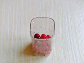 首先把新鲜蔓越莓洗干净，放入杯中，