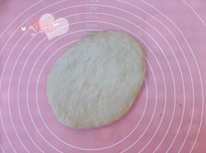 先做4个面团的整形。将松弛好的面团取出，用手轻拍排气。