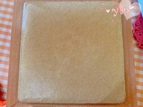 烤好的蛋糕取出，放晾网上晾凉，撕开四边的油布。