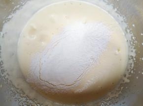 分两次筛入低筋面粉，每一次筛入以后都要用刮刀从底部翻拌均匀，再进行下一次筛入。