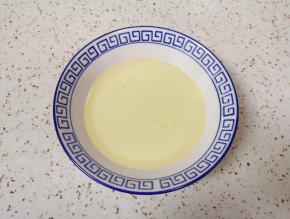 将牛奶和玉米油倒入小碗里。