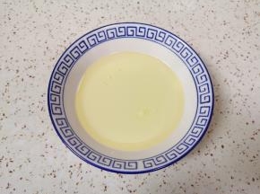 将牛奶和玉米油倒入小碗里。