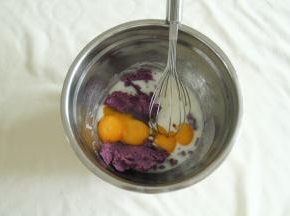 放入压成泥的紫薯和蛋黄，用蛋抽先之字形混合一下。再用电动打蛋器，搅打一会，打到细腻，基本看不见大的紫薯颗粒。想要超细腻的糊，也可以用料理机或者破壁机打一下！