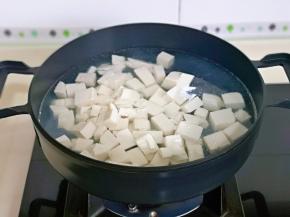 锅中加入水烧开，下豆腐块焯水，大火煮1分钟捞出淋干水分。