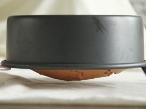 烤到时间，蛋糕膨胀到最高点略有回落，烤熟了。断电，出炉再次震模具震出热气后立即倒扣冷凉。今天蛋糕凸出好多，所以直接架在两个冷凉架中间，保持姿态！