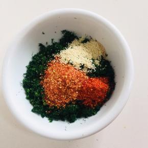 切好的小茴香装入碗中，放入三勺粗辣椒面，一勺细辣椒面，一把白芝麻！