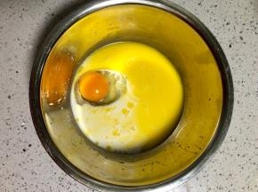另取一个盆，把鸡蛋、融化的黄油和牛奶混合拌匀；