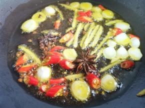 锅中热油，爆香蒜片、姜丝、小米椒、花椒、八角，