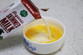 接着倒入牛奶，顺时针搅拌均匀，牛奶和鸡蛋完美结合。如果有气泡，用勺子撇掉。