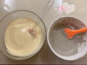 取一半蛋白加入黑芝麻面糊里，剩余的一半加入蛋黄面糊里，分别翻拌均匀。