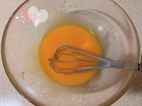 蛋黄里加入玉米油，用蛋抽划一字翻拌均匀。
