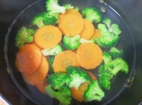 蒸米饭的时间里处理一下蔬菜，西蓝花掰成小朵，用淡盐水浸泡一下洗干净，胡萝卜去皮洗干净切成片，将西蓝花和胡萝卜一起焯水煮熟，捞出晾凉备用。