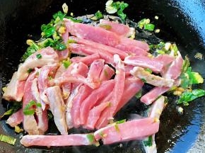 锅中倒入底油加热放入葱姜蒜爆香再放入切好的猪肉条
