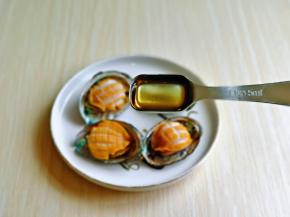 把小鲍鱼放壳里，加入料酒，每个鲍鱼肉上淋一点。