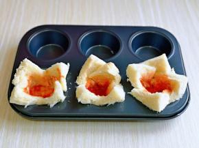 切好的吐司片放入模具中，折出盅的形状，涂上番茄酱。(自己喜欢的酱料都可以)