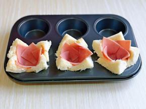 再把切好的火腿片做出盅状，放在吐司片上面，轻轻按压一下，压平整。