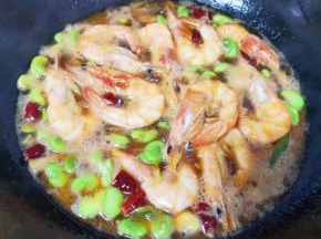 加入开水烧开，焖炒10分钟，让虾和蚕豆入味。