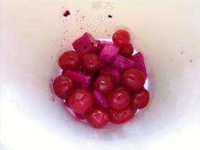 将一半的火龙果和一半的美国蔓越莓鲜果放进榨汁杯（榨汁杯比较小，一次放不下，分两次做）。