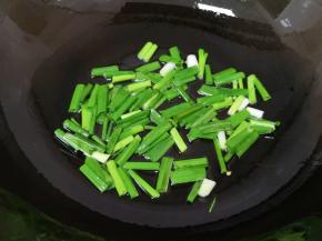 炒锅内倒适量的食用油烧热，下入葱段小火炒香。