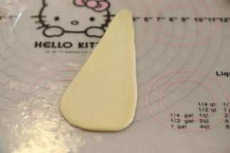 取一小份面团，轻压排气后搓成水滴状，再擀成三角形。