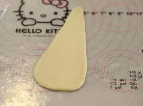 取一小份面团，轻压排气后搓成水滴状，再擀成三角形。