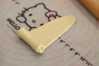 从下往上卷，一边卷一边轻拉尖角。