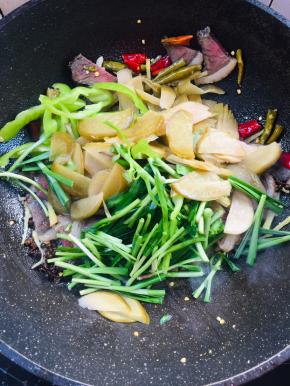 放入酸萝卜，青椒，韭菜段翻炒片刻！