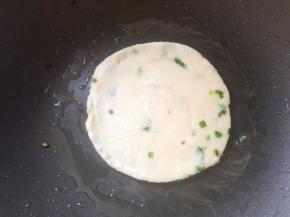 锅中刷油，放入葱油饼小火煎，中途不停翻面拍打