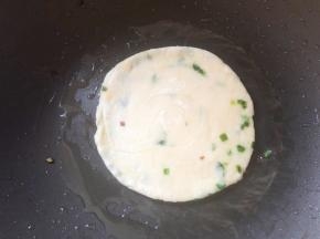 锅中刷油，放入葱油饼小火煎，中途不停翻面拍打