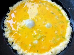 锅中倒入适量油加热鸡蛋打散放入香葱拌匀倒入锅中