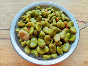 煮好的蚕豆捞出，放在滤网里面沥干水分。