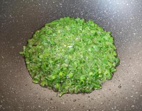 炒锅内倒适量的食用油烧热，下入小葱叶炒香。