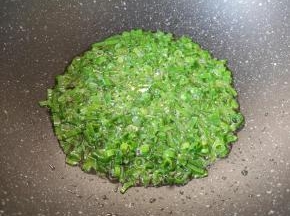 炒锅内倒适量的食用油烧热，下入小葱叶炒香。