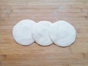 擀成中间稍厚边缘薄的包子皮。