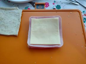 然后依次铺上美式火腿、芝士片。