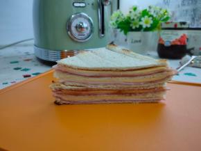 到时间自动跳闸，取出烤架，再用锋利的刀从两个对角线切开，切成两个三角形，然后再摞起来，我们的拿破仑三明治就做好了，美好的一天从早餐开始。