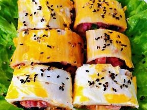 盘中铺上绿色生菜装饰一下烤冷面切成大块摆入盘中撒上黑芝麻就大功告成了