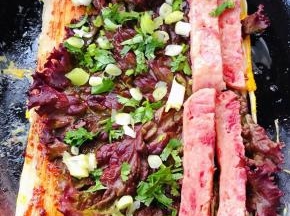 放上一片紫色生菜和午餐肉撒上葱花和香菜粒