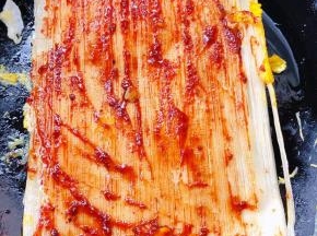 鸡蛋略微定型后轻轻翻过来中小火煎至另一面冷面上面均匀涂抹一层调好的料汁