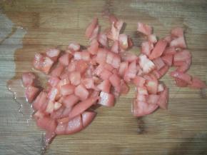 西红柿先放入热水中烫一烫，剥去外皮，然后也切成小丁