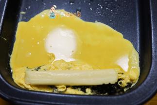 半凝固的时候把鸡蛋全部堆放在一起，然后放上奶酪，继续放鸡蛋液