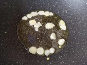 炒锅内继续倒油烧热，下入蒜片炝香。