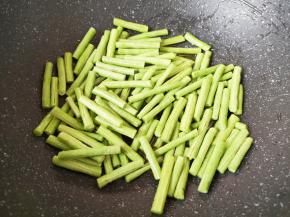 炒锅内倒多一点食用油烧热，下入豇豆段。