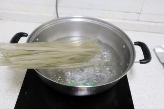 煮锅倒入适量的水，放入红薯粉，我的锅比较小，一下不能全部放下去，需要把煮软的粉条往下移，这里就能把粉条全部在锅里
