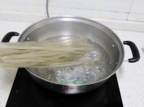 煮锅倒入适量的水，放入红薯粉，我的锅比较小，一下不能全部放下去，需要把煮软的粉条往下移，这里就能把粉条全部在锅里